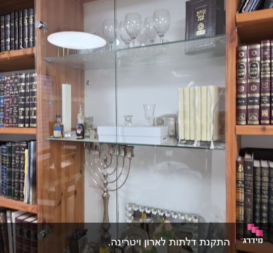 ארון זכוכית עם כוסות יין וספרים